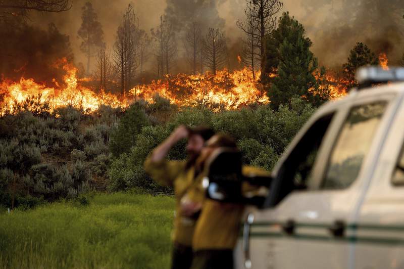 California wildfire advances as heat wave blankets US West